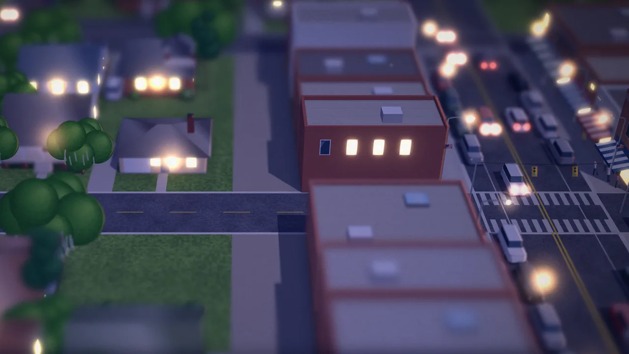 A model town at night seen from above, its windows and car lights glowing