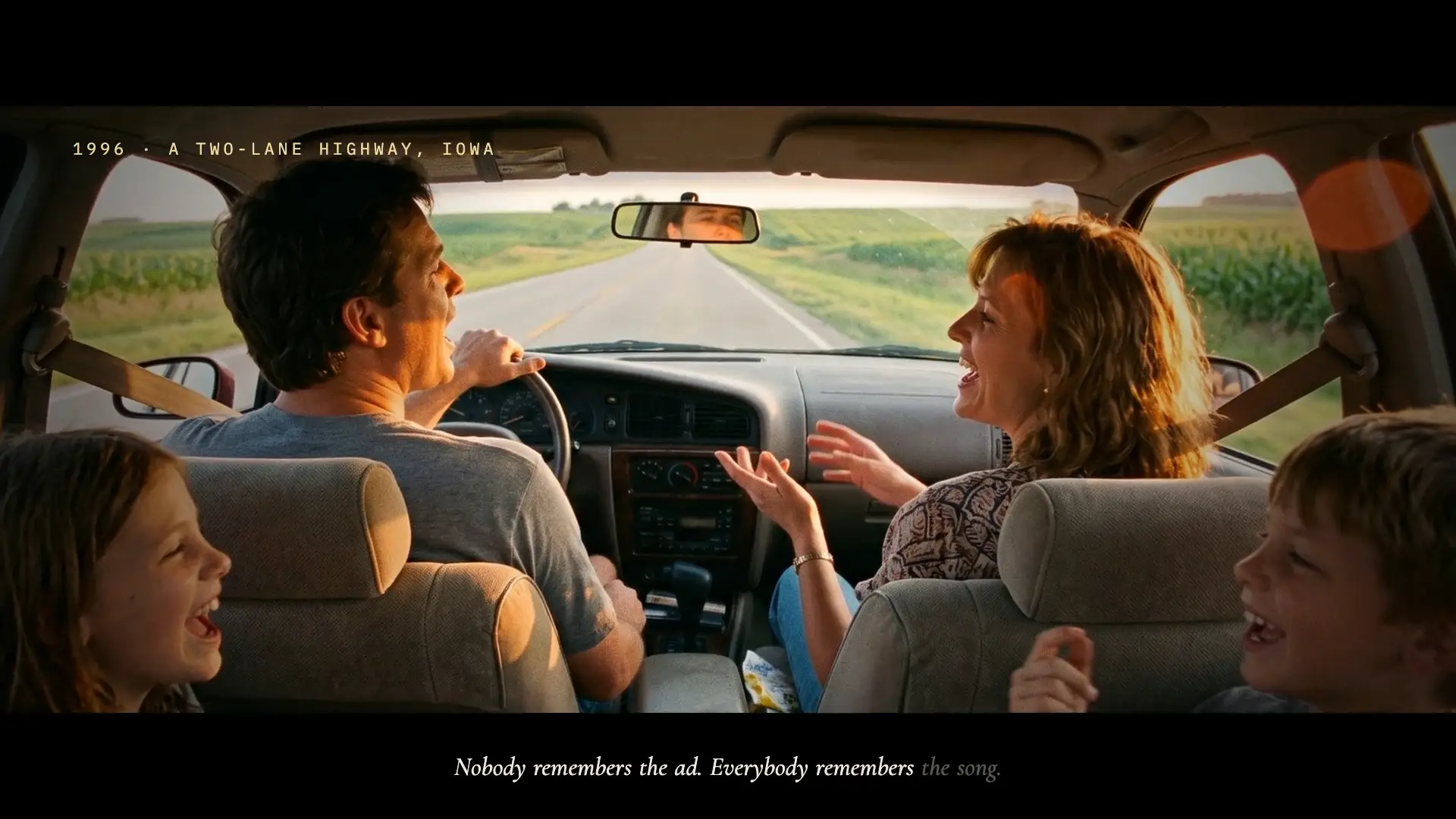 A family sings along in the car on a two-lane highway in 1996